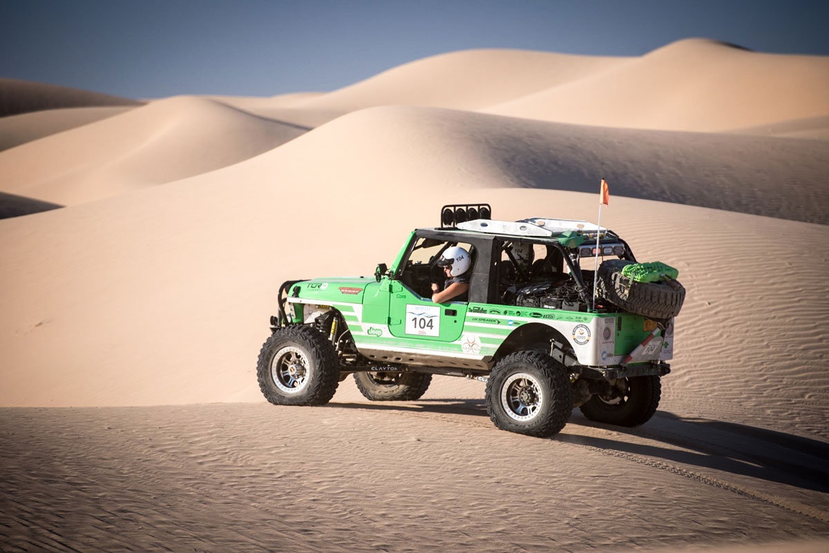 Jeep driving over sand dunes