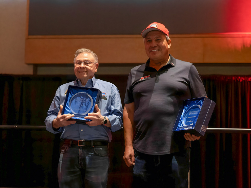 Two men receiving awards at reception.