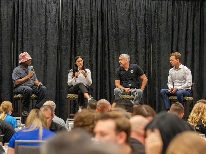 Panel of speakers in front of audience.