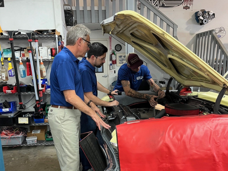 Rick Love looking under the hood of a car.