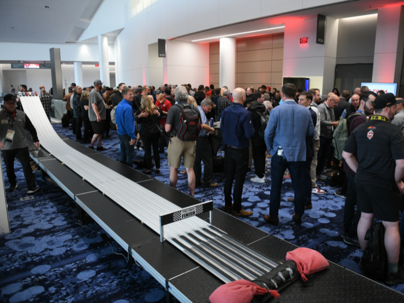 People socializing around a Pinewood derby track