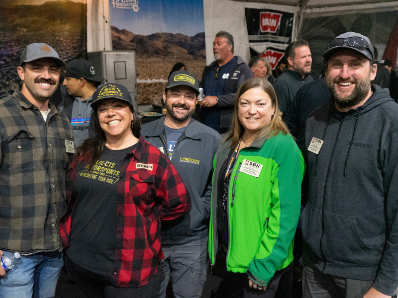 Group of people smiling at the King of Hammers mixer.