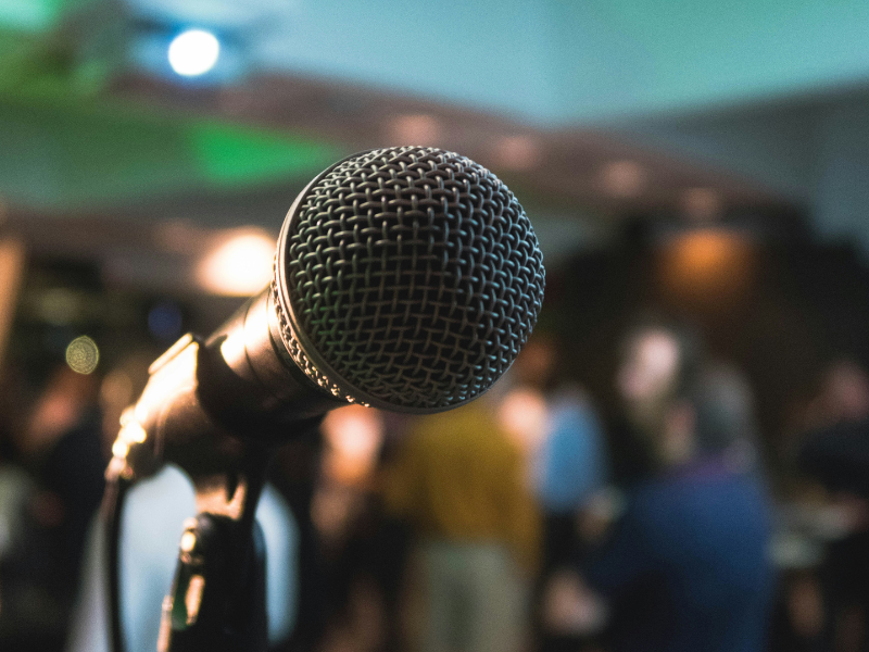 microphone on stand with blurred background of crowd